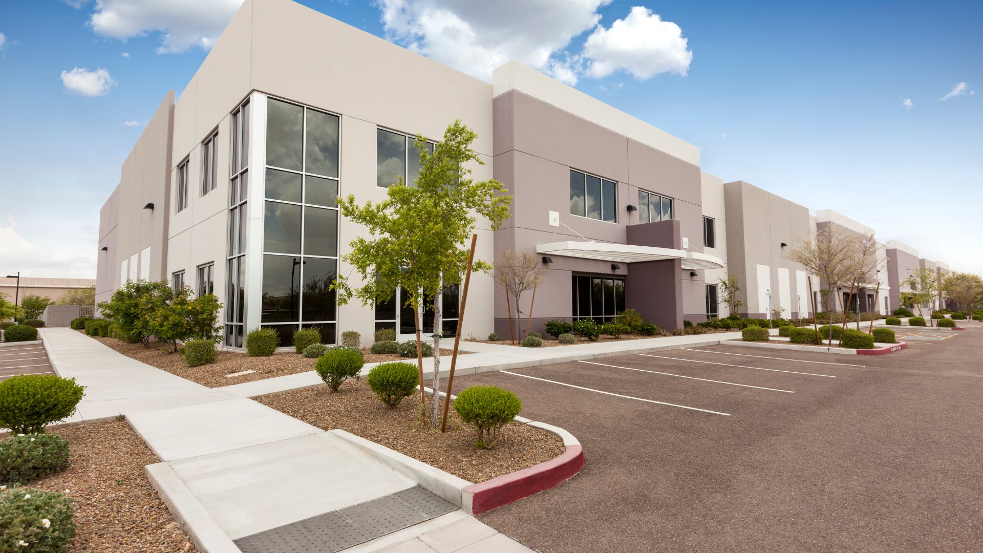 Modern office building with parking lot and landscaped grounds