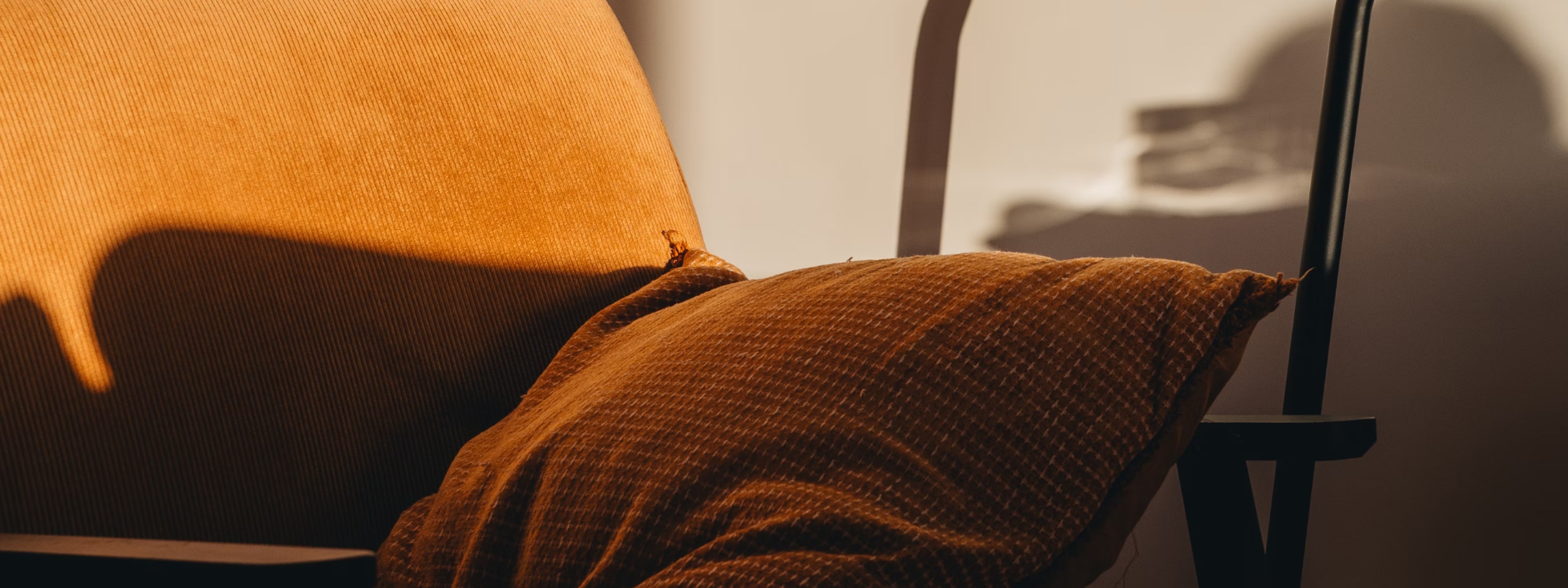 Warm-toned textured fabric draped over a chair with soft shadows